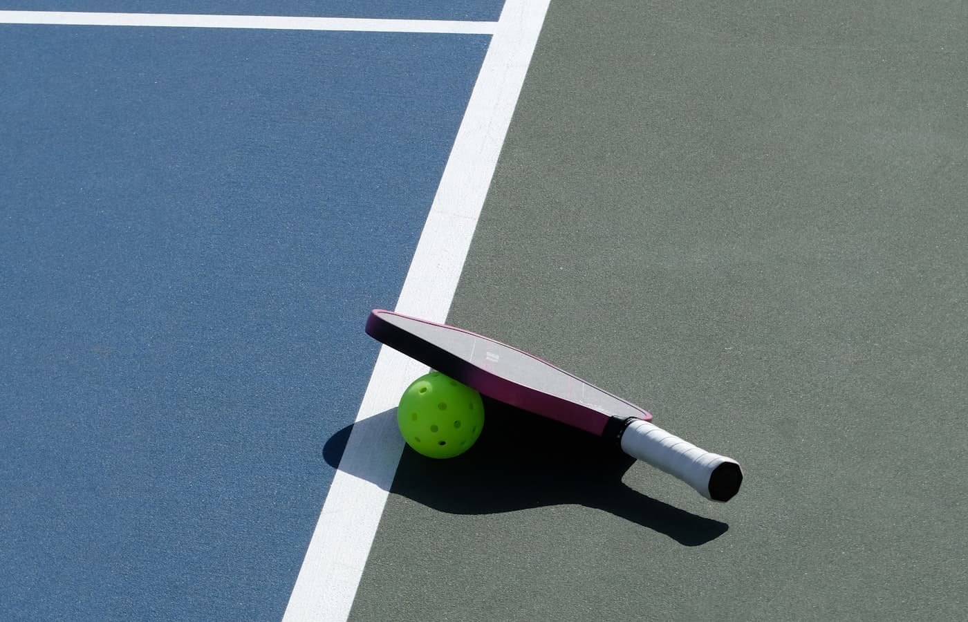 Close-up of the non-volley zone line on an indoor pickleball court beside the net